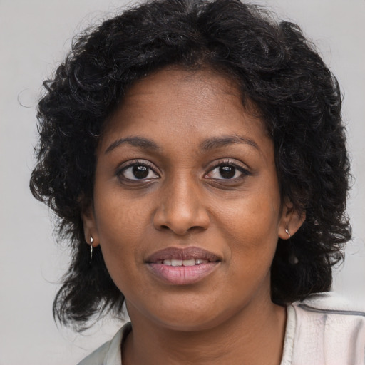 Joyful black young-adult female with long  brown hair and brown eyes