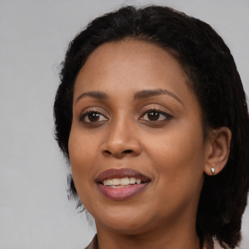 Joyful black young-adult female with medium  black hair and brown eyes