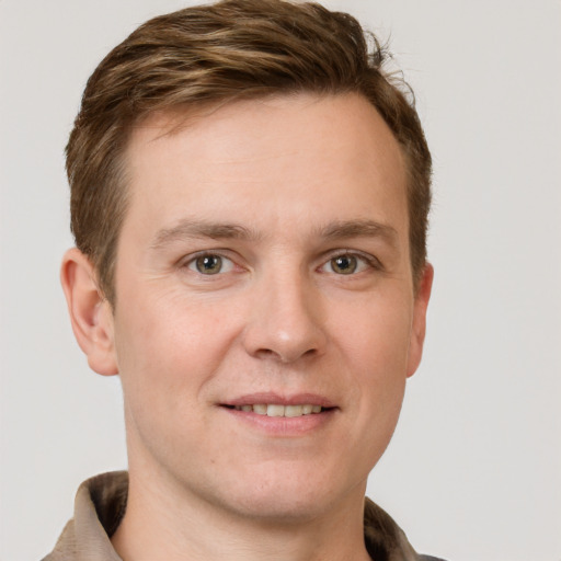 Joyful white young-adult male with short  brown hair and grey eyes