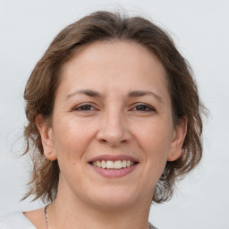 Joyful white adult female with medium  brown hair and grey eyes