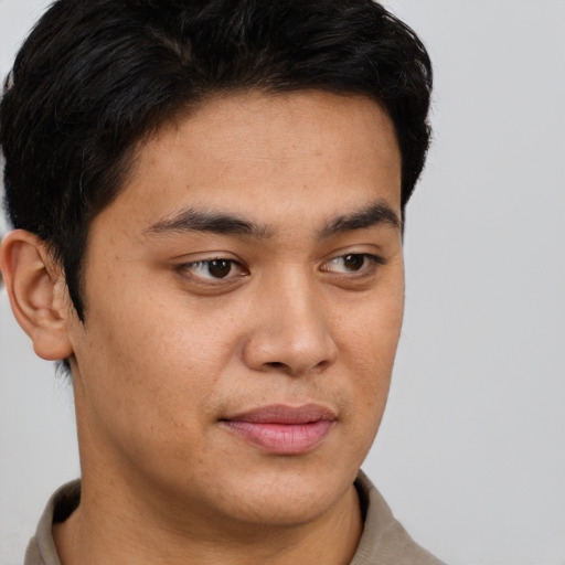 Joyful latino young-adult male with short  brown hair and brown eyes