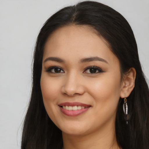 Joyful latino young-adult female with long  brown hair and brown eyes