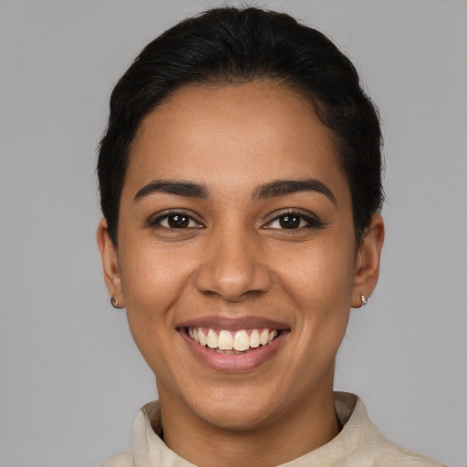 Joyful latino young-adult female with short  brown hair and brown eyes