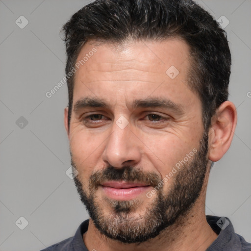 Joyful white adult male with short  black hair and brown eyes