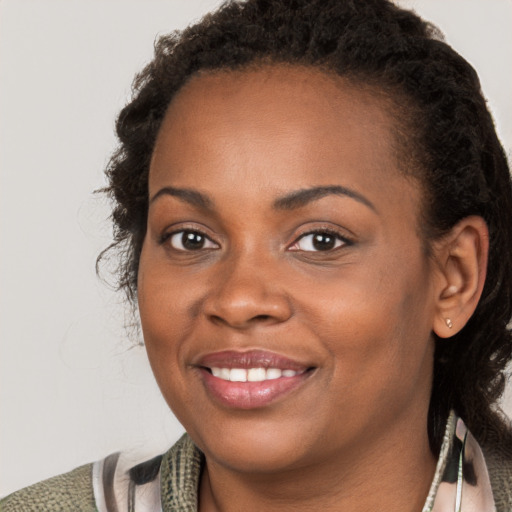 Joyful black young-adult female with short  brown hair and brown eyes