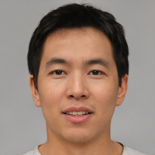 Joyful asian young-adult male with short  brown hair and brown eyes