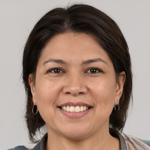 Joyful white adult female with medium  brown hair and brown eyes