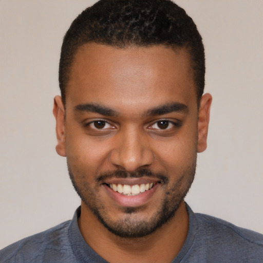 Joyful black young-adult male with short  brown hair and brown eyes