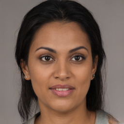 Joyful latino young-adult female with medium  brown hair and brown eyes