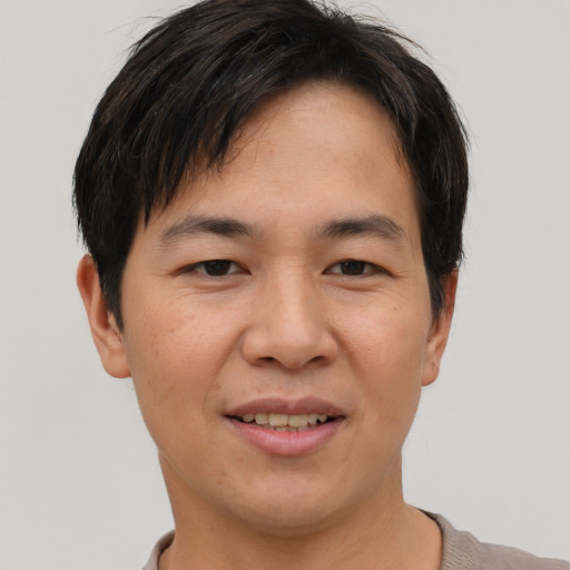 Joyful asian adult male with short  brown hair and brown eyes
