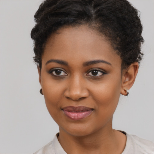 Joyful black young-adult female with short  brown hair and brown eyes