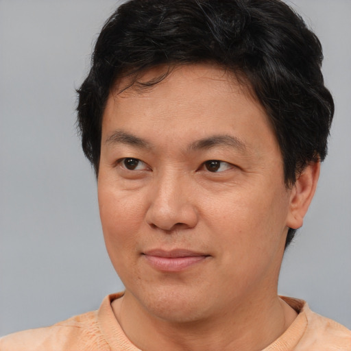 Joyful asian adult male with short  brown hair and brown eyes