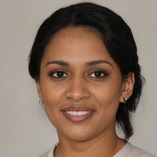 Joyful black young-adult female with medium  brown hair and brown eyes