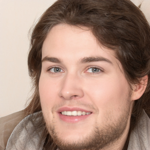 Joyful white young-adult male with medium  brown hair and grey eyes