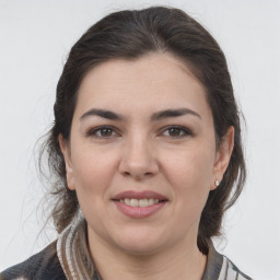 Joyful white young-adult female with medium  brown hair and grey eyes