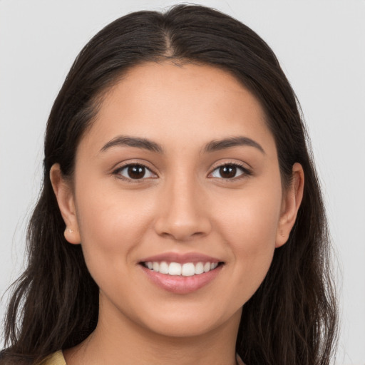 Joyful white young-adult female with long  brown hair and brown eyes