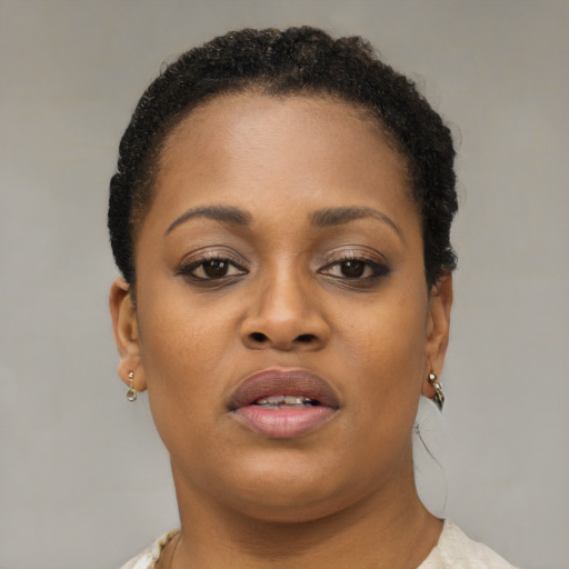 Joyful black young-adult female with short  brown hair and brown eyes