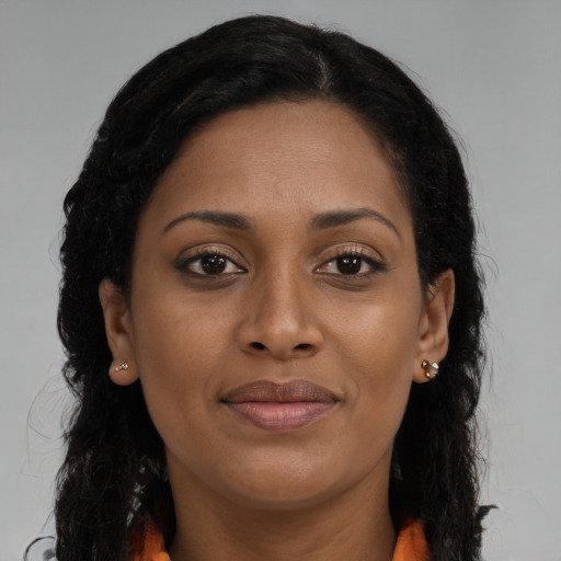 Joyful black young-adult female with long  brown hair and brown eyes