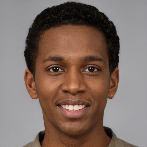 Joyful black young-adult male with short  brown hair and brown eyes