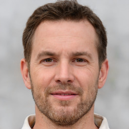 Joyful white adult male with short  brown hair and brown eyes