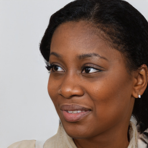 Joyful black young-adult female with short  brown hair and brown eyes