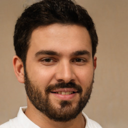 Joyful white young-adult male with short  black hair and brown eyes