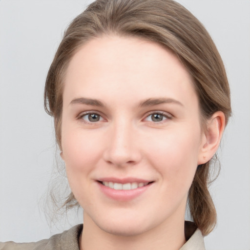 Joyful white young-adult female with medium  brown hair and grey eyes