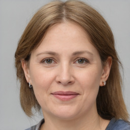 Joyful white adult female with medium  brown hair and grey eyes