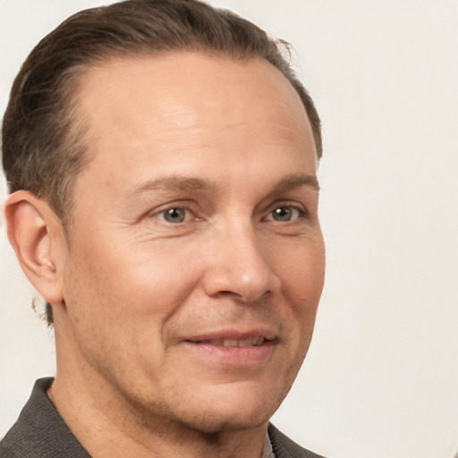 Joyful white adult male with short  brown hair and grey eyes