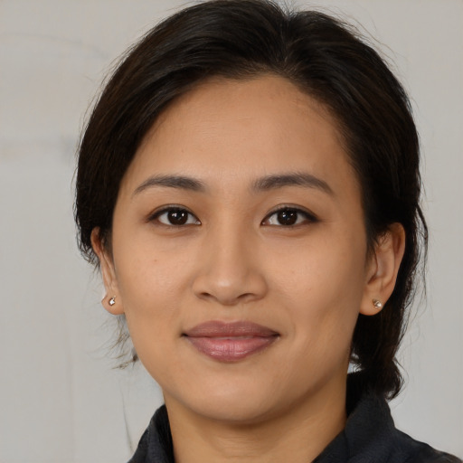 Joyful latino young-adult female with medium  brown hair and brown eyes