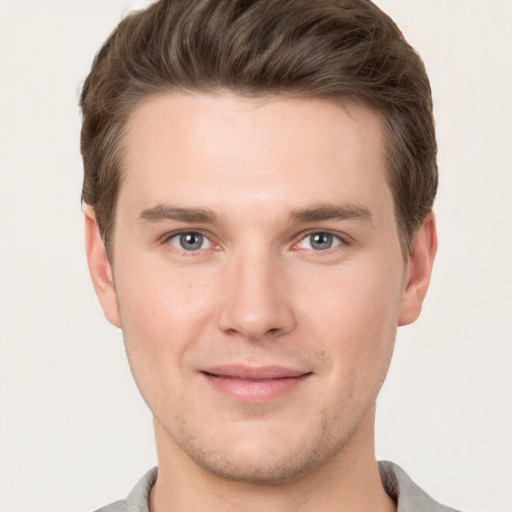 Joyful white young-adult male with short  brown hair and grey eyes