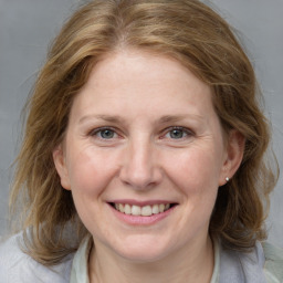 Joyful white adult female with medium  brown hair and blue eyes