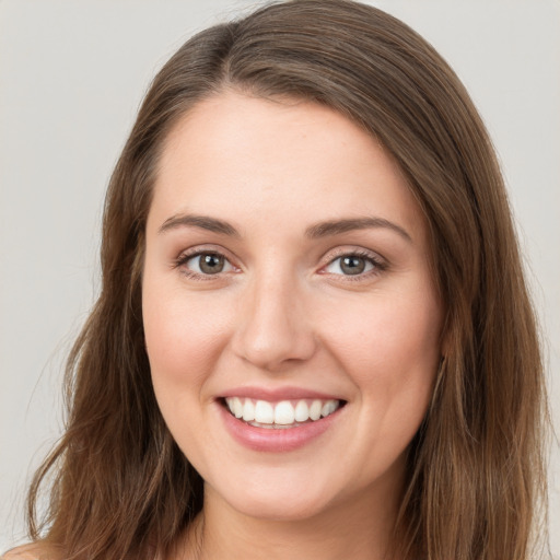 Joyful white young-adult female with long  brown hair and grey eyes