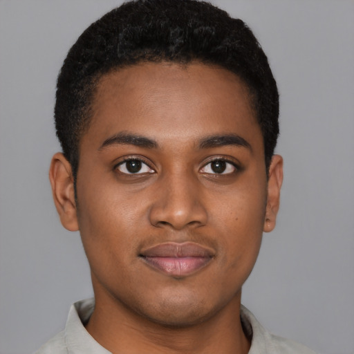 Joyful black young-adult male with short  black hair and brown eyes
