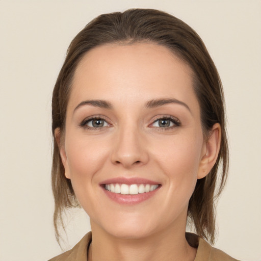 Joyful white young-adult female with medium  brown hair and grey eyes