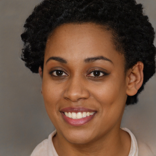 Joyful black young-adult female with short  brown hair and brown eyes