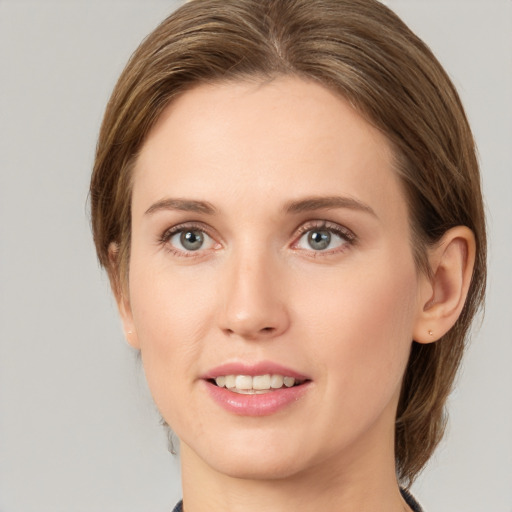 Joyful white young-adult female with medium  brown hair and green eyes