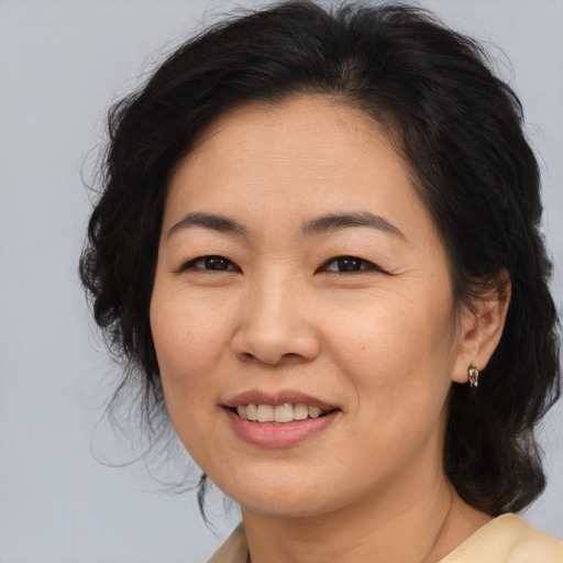 Joyful asian adult female with medium  brown hair and brown eyes