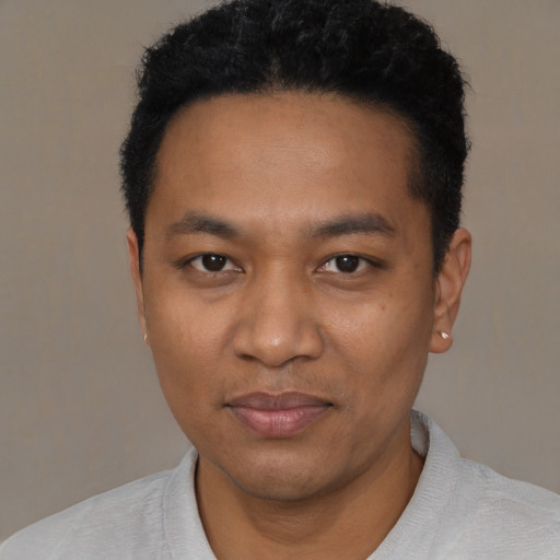 Joyful black young-adult male with short  black hair and brown eyes