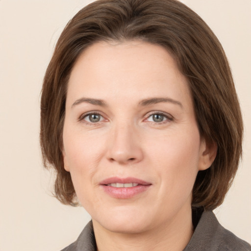 Joyful white adult female with medium  brown hair and grey eyes