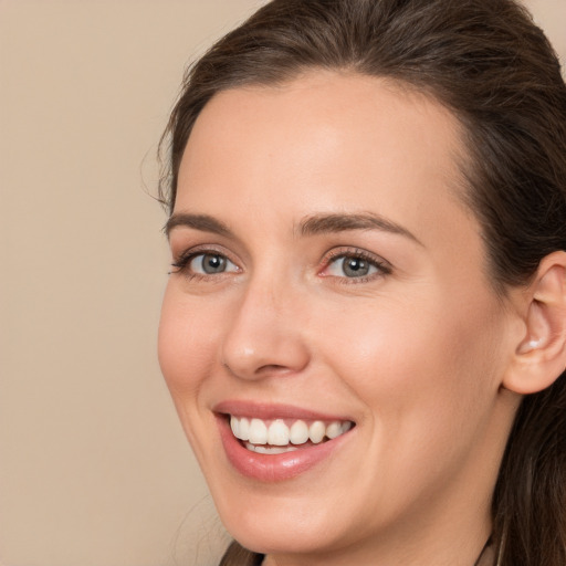 Joyful white young-adult female with long  brown hair and brown eyes