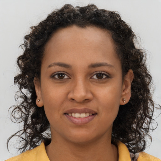 Joyful black young-adult female with long  brown hair and brown eyes