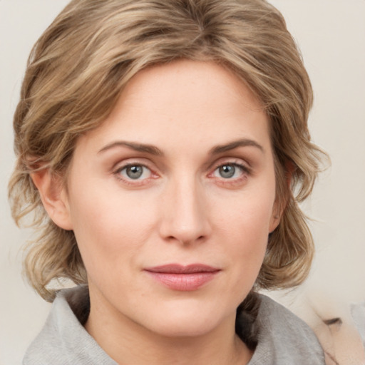 Joyful white young-adult female with medium  brown hair and blue eyes