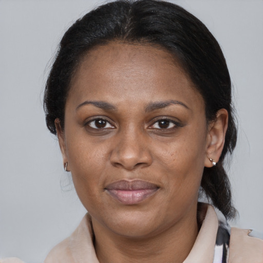 Joyful black adult female with medium  brown hair and brown eyes