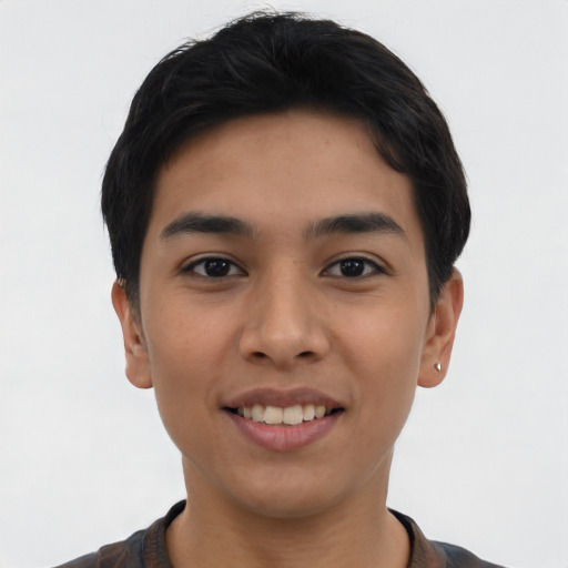 Joyful latino young-adult male with short  black hair and brown eyes