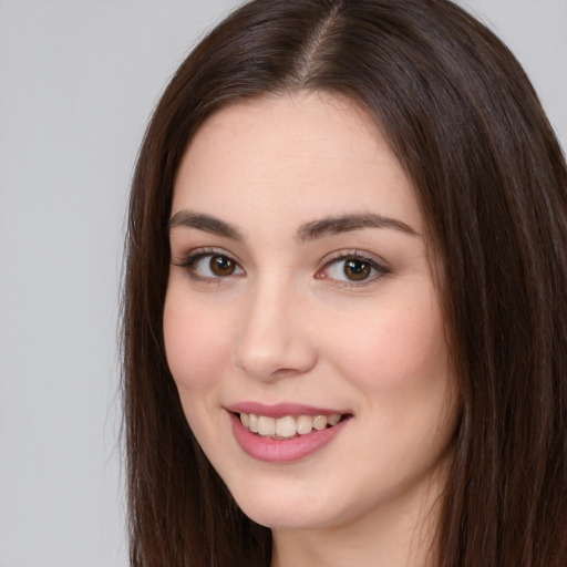 Joyful white young-adult female with long  brown hair and brown eyes