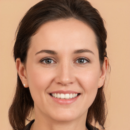 Joyful white young-adult female with long  brown hair and brown eyes