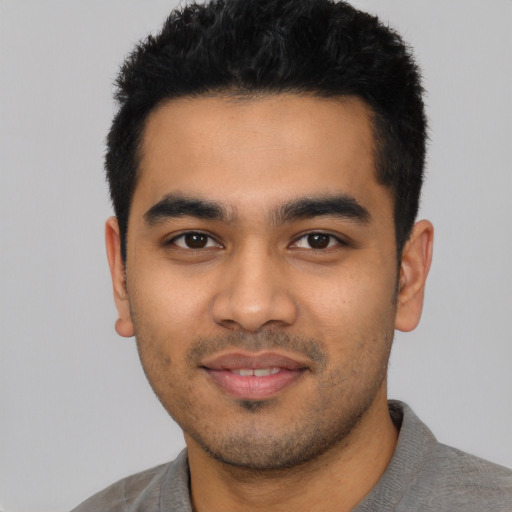 Joyful latino young-adult male with short  black hair and brown eyes