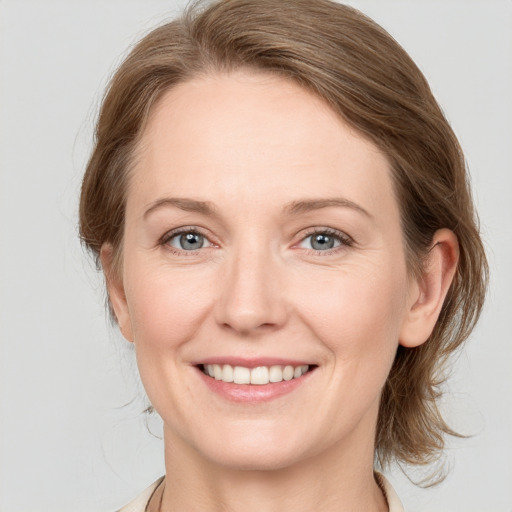 Joyful white young-adult female with medium  brown hair and blue eyes