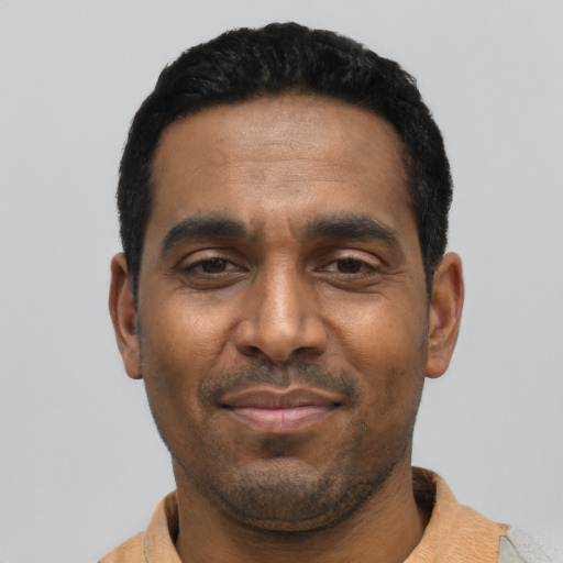 Joyful latino adult male with short  black hair and brown eyes